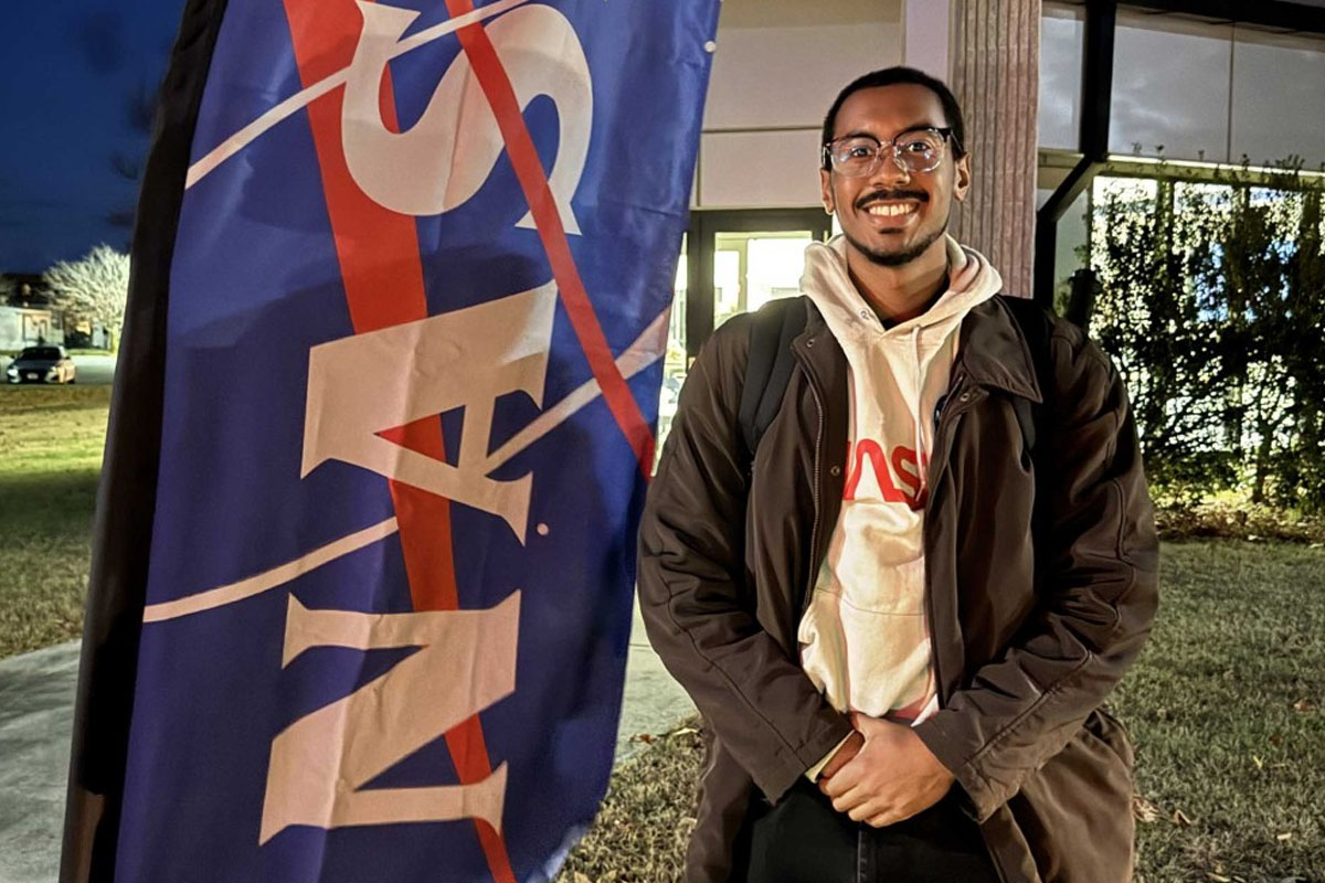 Chad McElroy standing in front of NASA sign