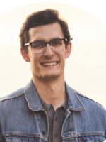 Smiling man with glasses and denim jacket